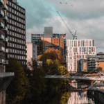 A backdrop of manchester showing construction cranes towering above the buildings.