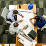 Site managers sitting around a table deciding whether to hire temporary or permanent construction workers