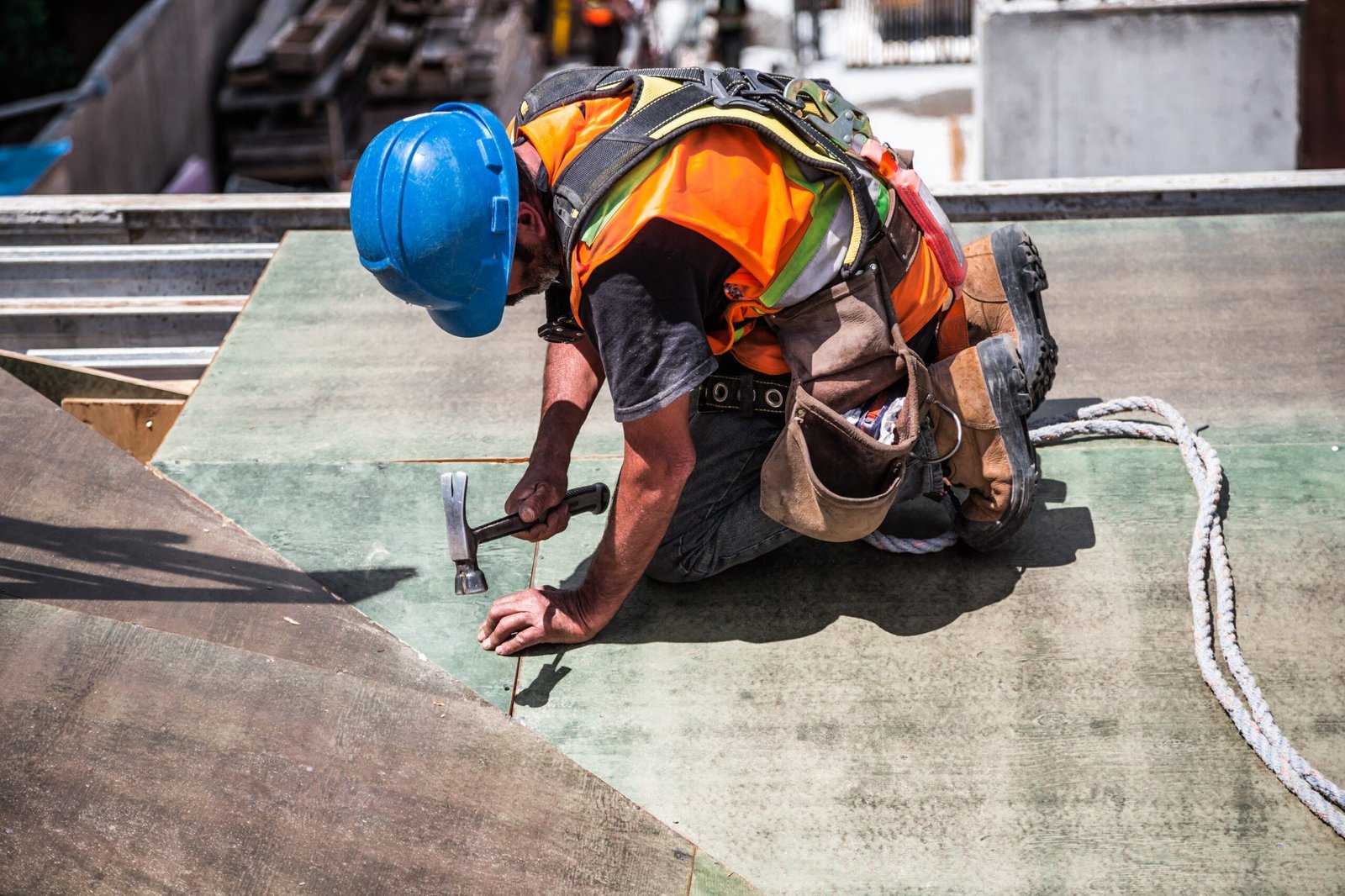 a man with a hard hat using a hammer on the ground to show why construction recruitment specialists are better than direct hiring